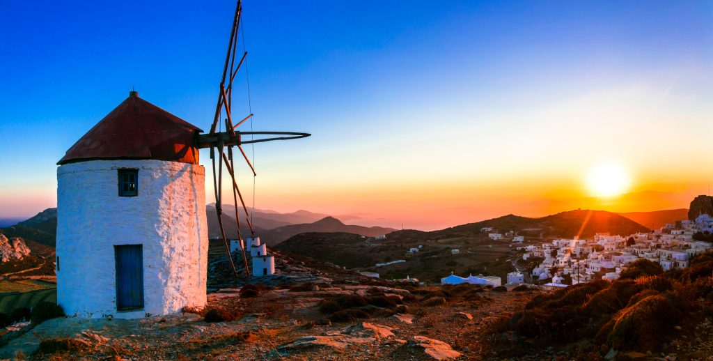 Idyllic landscape with windmills over sunset. Amorgos isalnd, Greece.