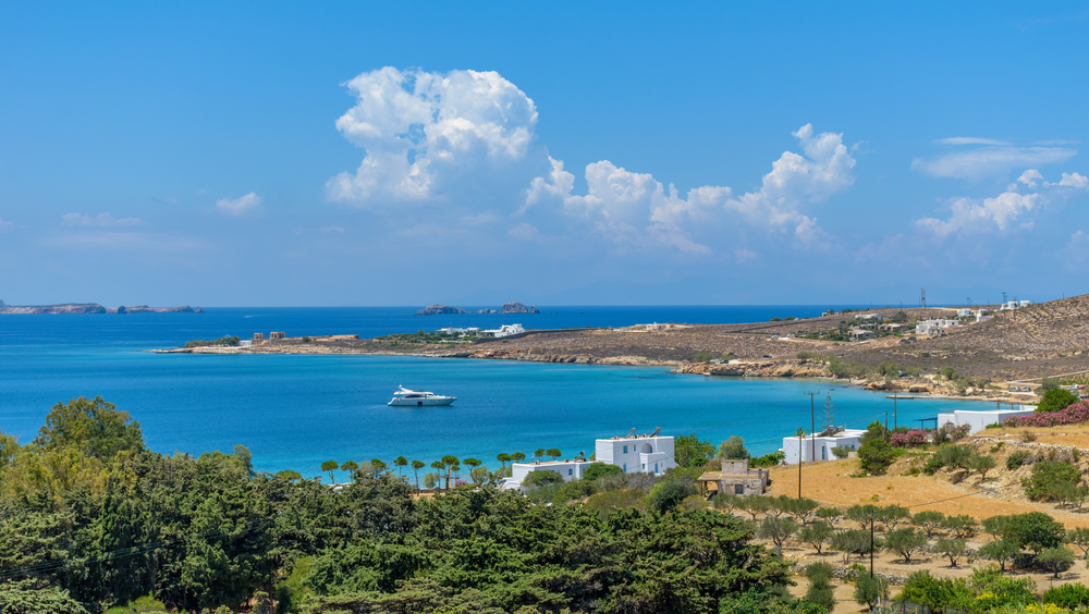Panorama Cycladitic view with whitewashed houses as a forground and calm aegean sea as background a sunny day with a blue sky and a few clouds near krios beach, Paros island, Greece - valantis minogiannis / shutterstock