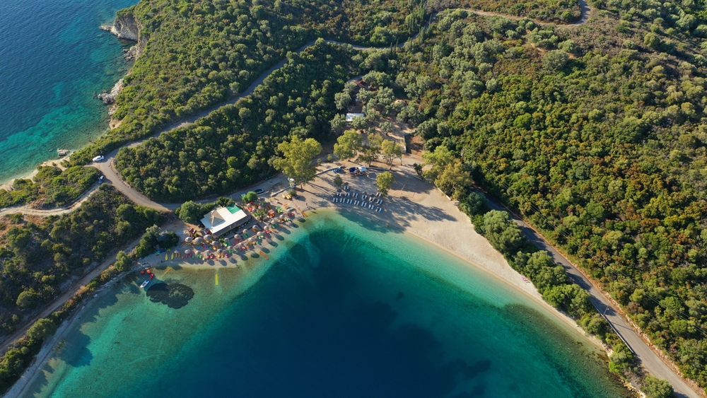 Aerial drone photo of organised with sun beds and umbrellas paradise beach of Fanari with crystal clear turquoise sea, Meganisi island, Ionian, Greece - Aerial-motion / shutterstock